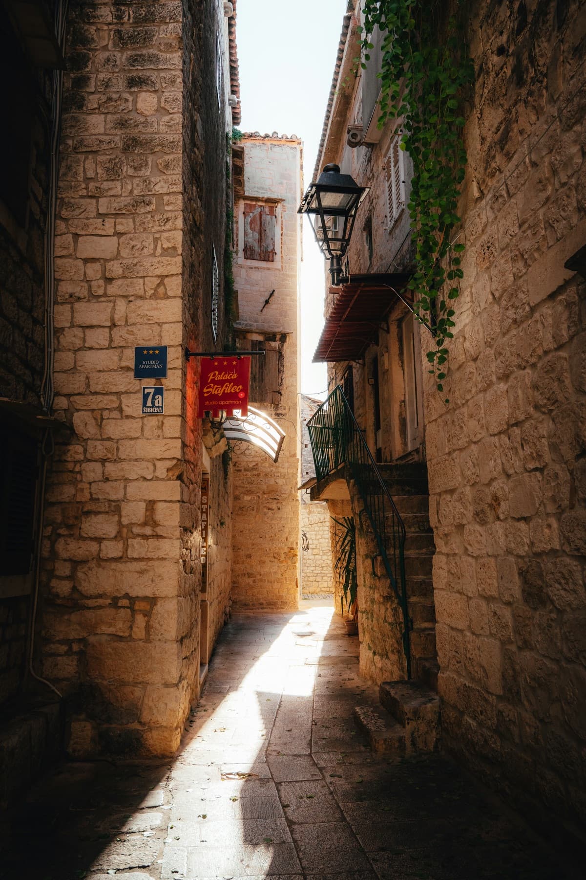 A narrow, sunlit stone alley in Trogir